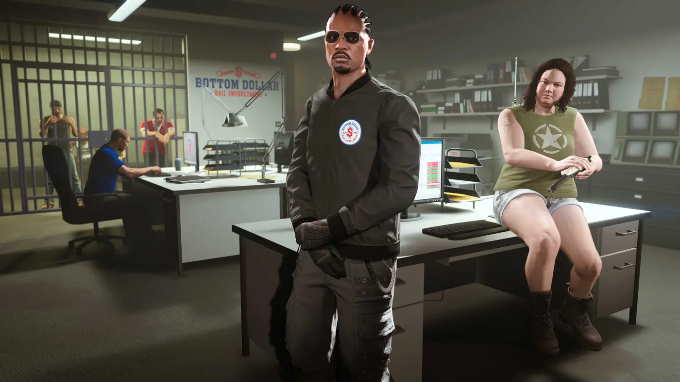 Intérieur d'un Bail Office de GTA Online : Jenette Eccles assise sur le coin d'un bureau à droite, un agent en veste Bottom Dollar au centre, une cellule avec deux prisonniers et un poste informatique Bail Enforcement System à gauche, murs de dossiers et écrans de vidéosurveillance