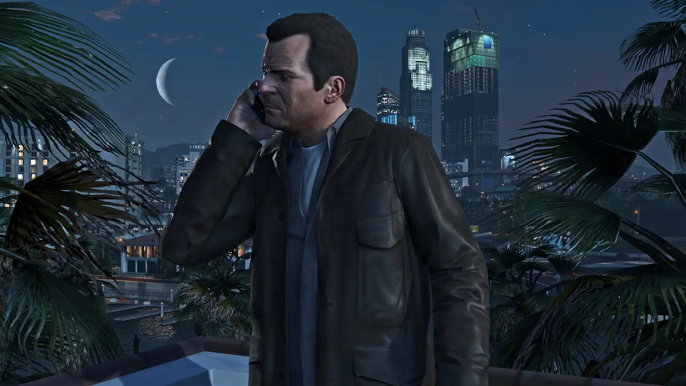 Michael au téléphone la nuit devant les gratte-ciels de Los Santos, dans GTA 5