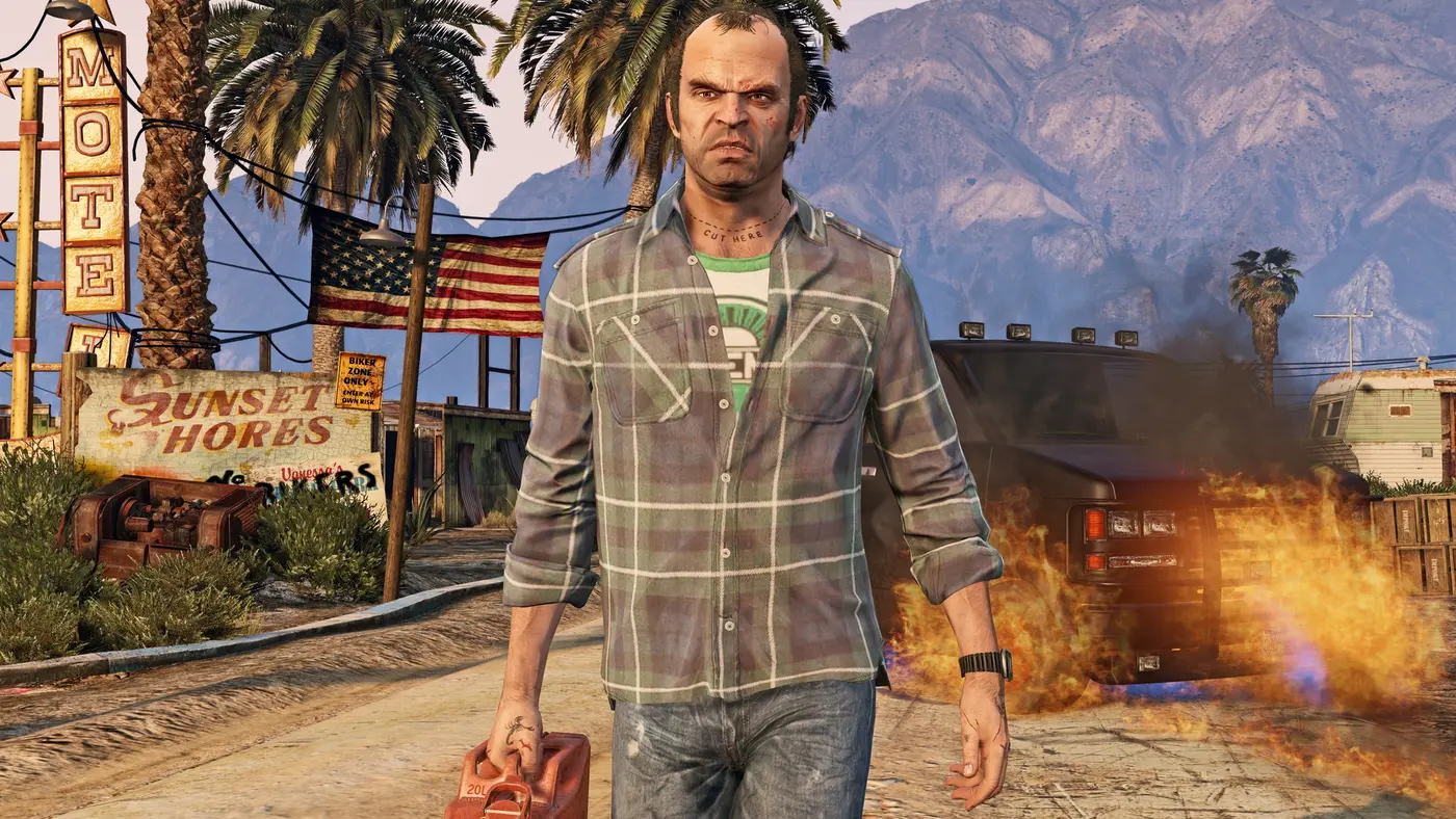 Trevor Philips, un bidon d'essence rouge à la main, marchant devant un van en flammes dans un décor désertique de GTA V, panneaux de motel et de bar, drapeau américain et palmiers, montagnes à l'arrière-plan