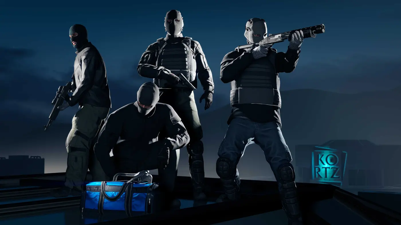 Capture officielle de GTA Online : quatre braqueurs en cagoule et gilet pare-balles, armés d'un fusil à pompe et d'un pistolet-mitrailleur, posés sur un toit au crépuscule devant l'enseigne lumineuse KORTZ, un sac de sport bleu à leurs pieds