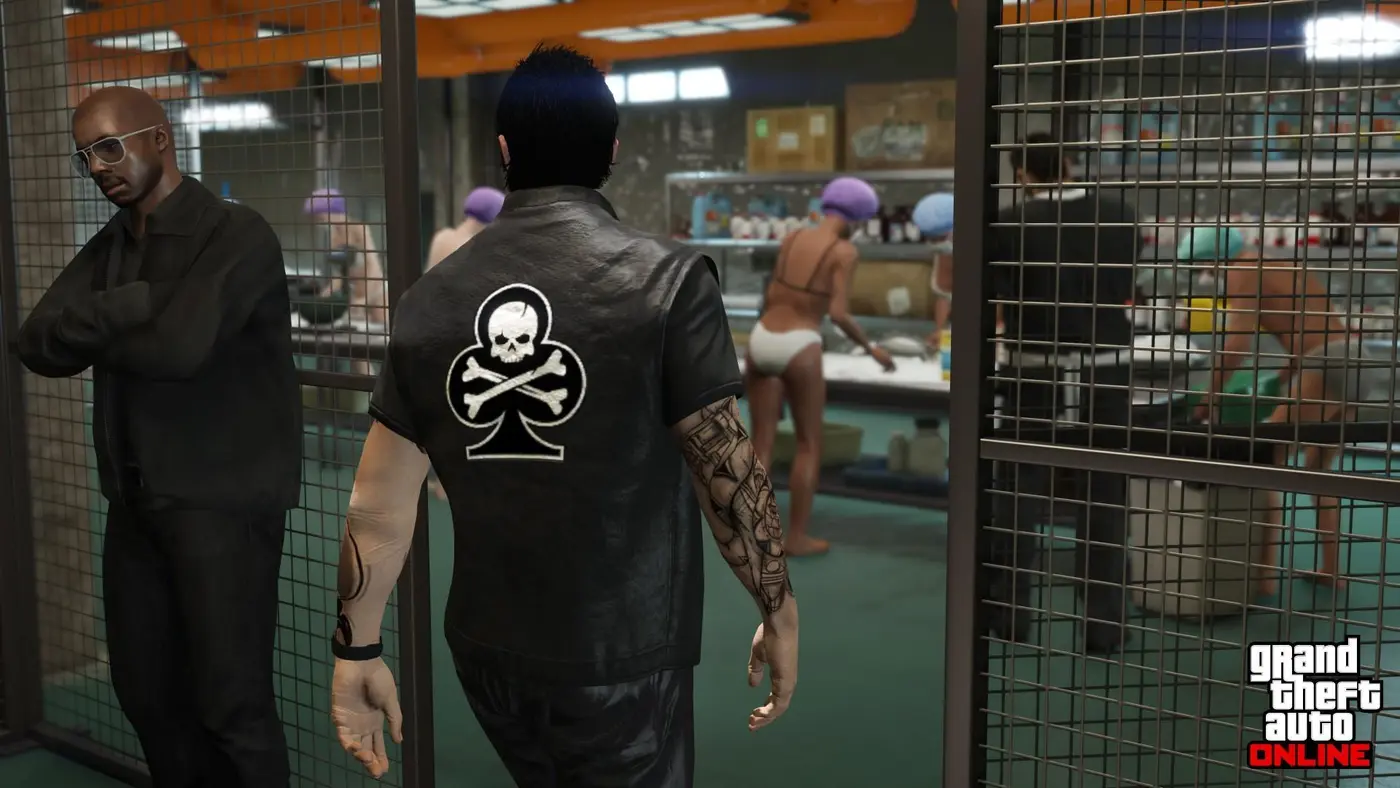 Dans un laboratoire de cocaïne de GTA Online, un membre du Motorcycle Club en gilet de cuir observe, derrière un grillage, des ouvriers en sous-vêtements et charlottes qui conditionnent le produit sur des plans de travail