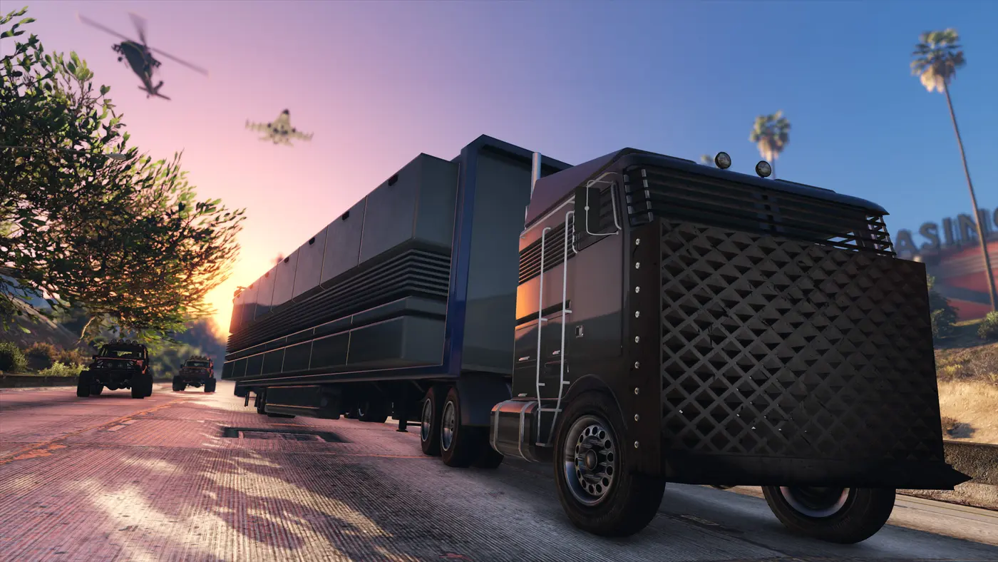 Le Mobile Operations Center, énorme semi-remorque de commandement noir, roule sur une route de Los Santos au coucher du soleil, un hélicoptère et un jet dans le ciel, des buggies en escorte