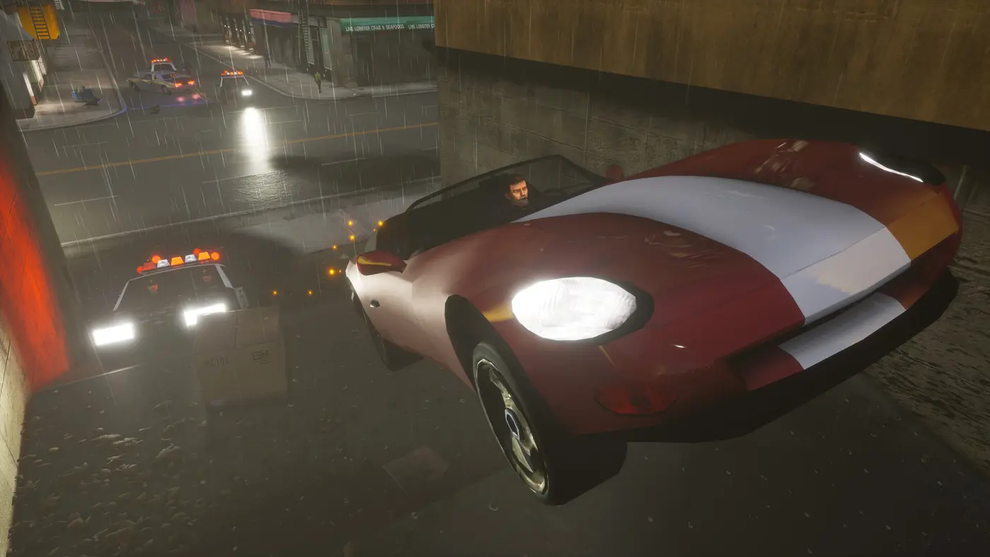 Rue de Liberty City sous la pluie la nuit dans GTA III, voiture de sport rouge et blanche au premier plan et voitures de police gyrophares allumés dans la rue mouillée en arrière-plan