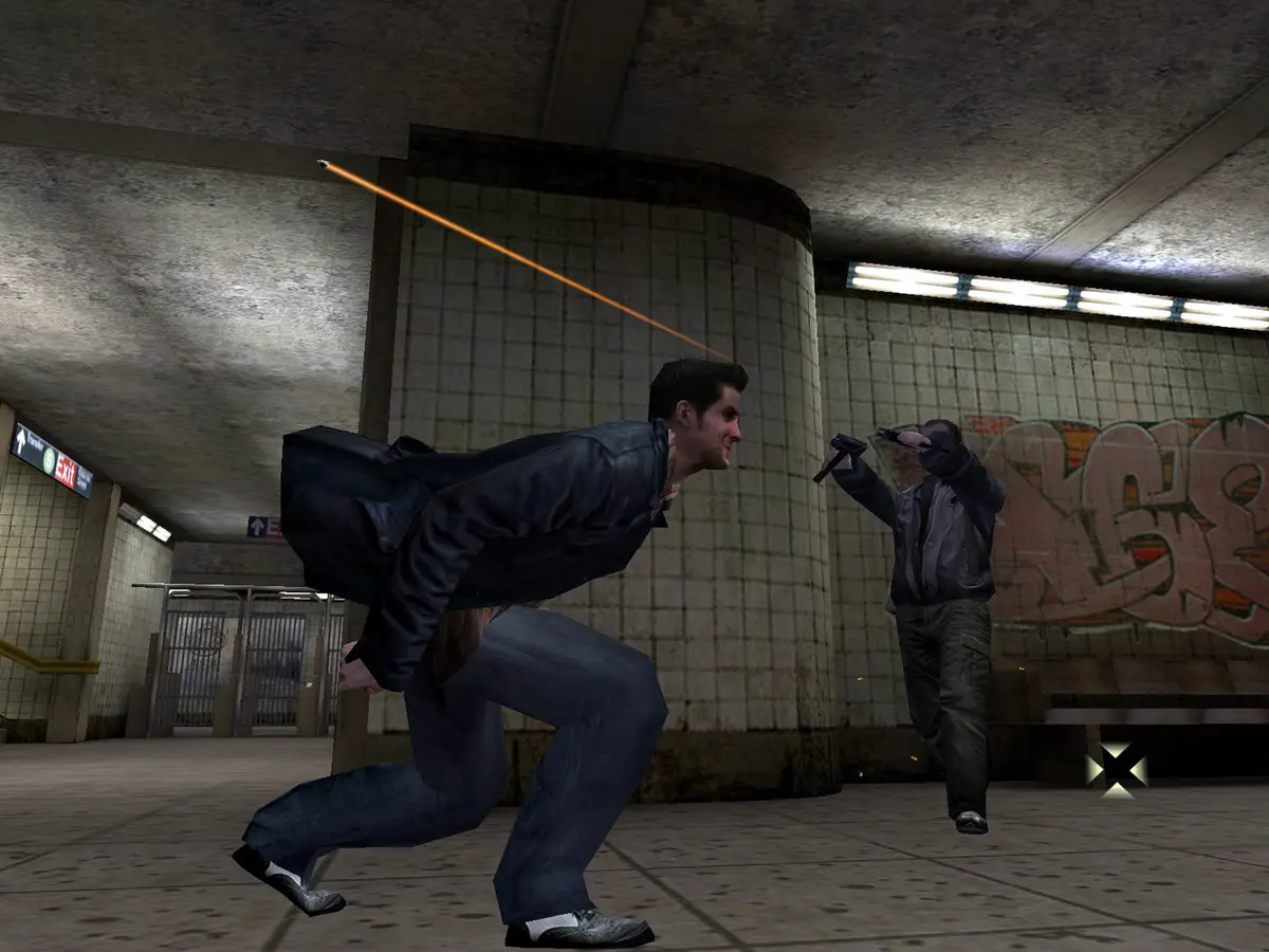 Capture de Max Payne (2001) : Max, en blouson de cuir, plonge sur le côté dans une station de métro carrelée pendant qu'un homme armé en blouson gris lui tire dessus, une traînée de balle orange traversant l'image