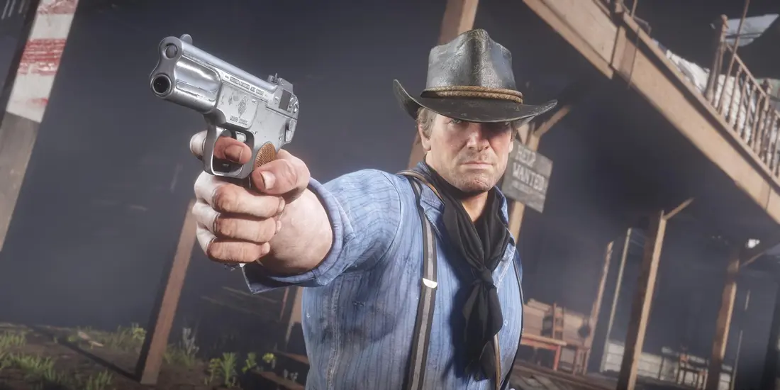 Gros plan d'Arthur Morgan, chapeau de cowboy et chemise bleue, braquant un pistolet de poche dans Red Dead Redemption 2, avec un rendu très détaillé du visage et des mains