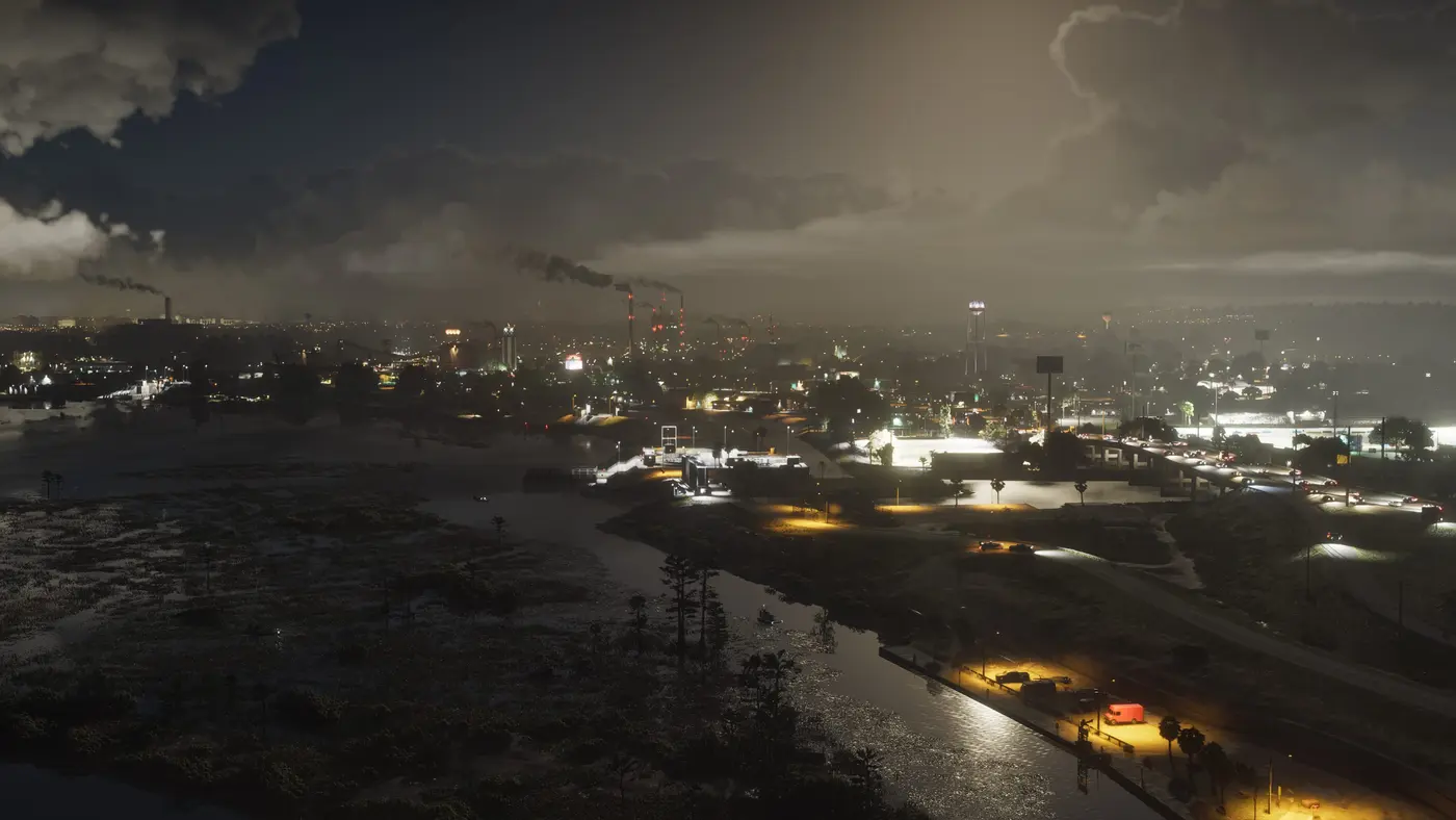 Vue aérienne nocturne d'Ambrosia dans GTA VI : des cheminées d'usine crachant de la fumée au-dessus d'une ville industrielle éclairée, marais sombres au premier plan et autoroute bordée de lampadaires