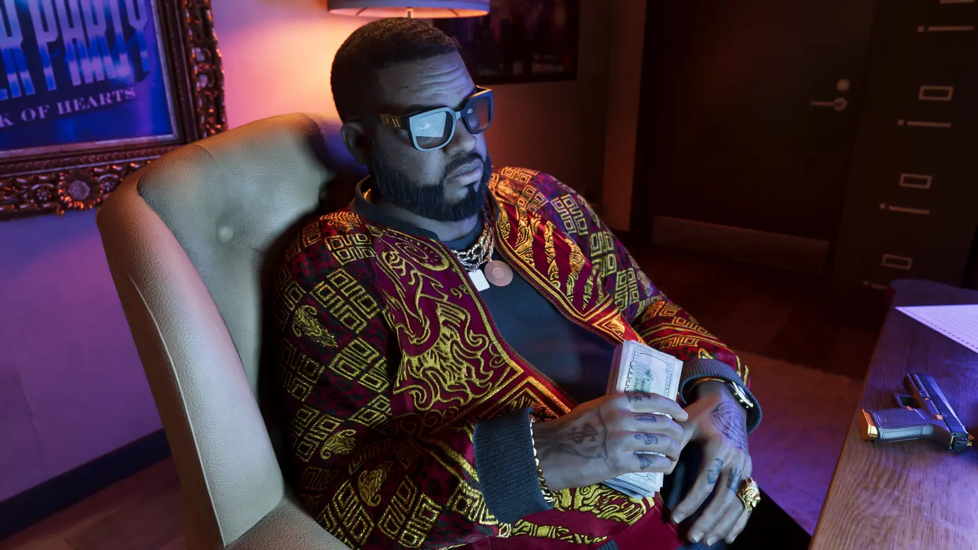 Boobie Ike dans GTA VI, assis dans un fauteuil sous une affiche « Jack of Hearts », comptant une liasse de billets, un pistolet posé sur le bureau, dans une lumière néon rose et violette