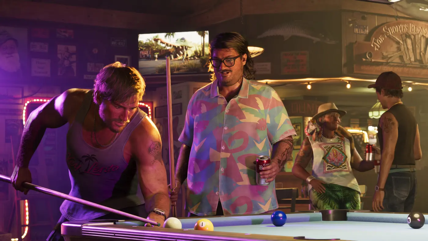 Intérieur d'un bar de Vice City dans GTA VI : deux hommes autour d'une table de billard, l'un penché pour jouer en débardeur, l'autre en chemise pastel une canette à la main, enseignes lumineuses et autres clients en arrière-plan