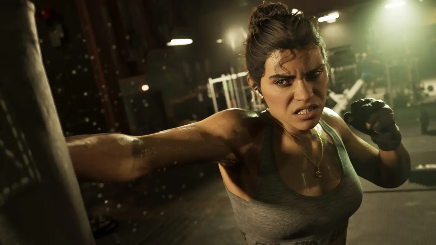 Lucia Caminos dans GTA VI, en débardeur et mitaines, le visage féroce, frappant un sac de boxe dans une salle de sport sombre éclairée au néon