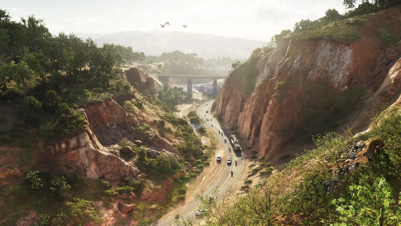 Gorge aux falaises rouges traversée par une route sinueuse et un pont au loin dans GTA VI, collines boisées de l'État de Leonida