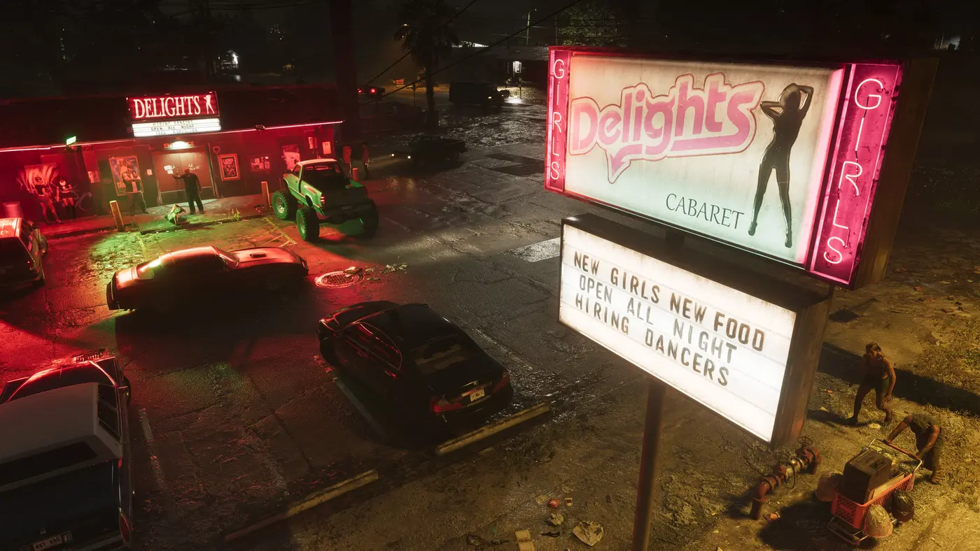 Parking nocturne du club de nuit « Delights » à Port Gellhorn dans GTA VI : enseigne néon rose à silhouette de danseuse, voitures et un buggy vert garés sur l'asphalte mouillé d'une rue en déshérence
