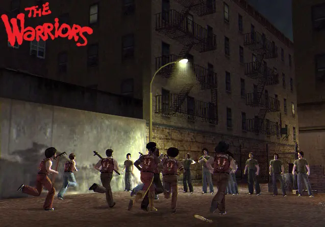 Bagarre de gang la nuit dans une rue du Bronx, membres des Warriors en gilets rouges affrontant une bande rivale sous un lampadaire, immeubles à escaliers de secours en arrière-plan, capture officielle du jeu The Warriors